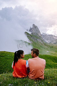 一对夫妇在 Italien Dolomites 度假远足，在 Seceda 峰上欣赏美景。 