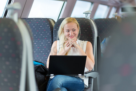 坐火车旅行时微笑的女人。