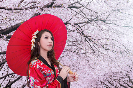 日本花艺摄影照片_身穿日本传统和服、红伞和樱花的亚洲女性。