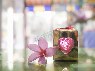 红色桃心摄影照片_礼物、爱和桃红色花提出的情人节背景