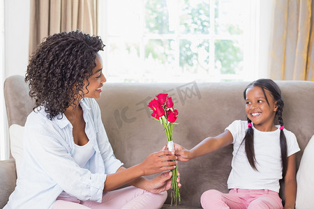 送玫瑰摄影照片_漂亮妈妈坐在沙发上，女儿送玫瑰