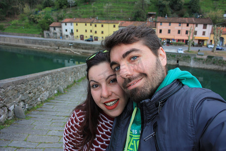 年轻人通过在 Ponte della Maddalena 的 Borgo a Mozzano 的 Lucca 的 Serchio 河上游览托斯卡纳的村庄来旅行