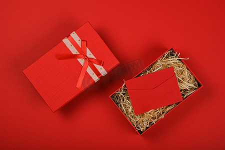 打开有丝带弓和信封的红色礼物盒