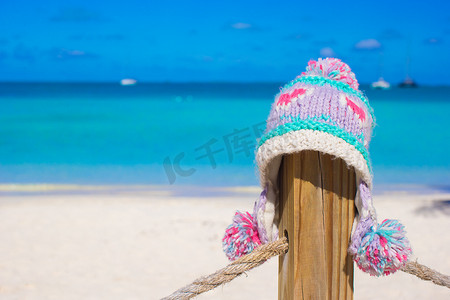 热带海滩围栏上的特写温暖针织帽