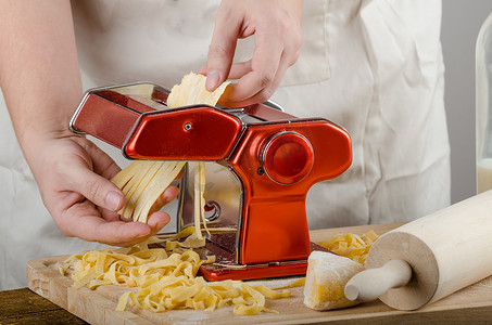 研磨加工摄影照片_厨师生产面食-意大利面食研磨机