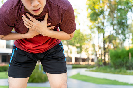 在公园跑步时，筋疲力尽的男跑步运动员患有心绞痛或哮喘呼吸问题。