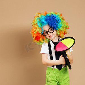 戴着小丑假发和眼镜玩接球游戏的孩子