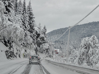 挪威人摄影照片_驾车穿过挪威的雪路和风景。