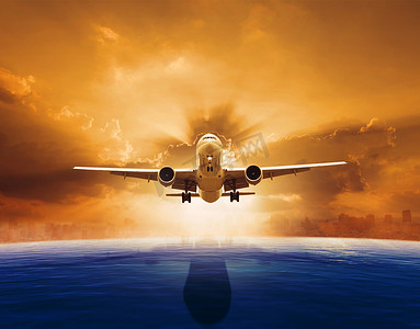 喷气式客机摄影照片_喷气式客机飞越美丽的海平面，日落