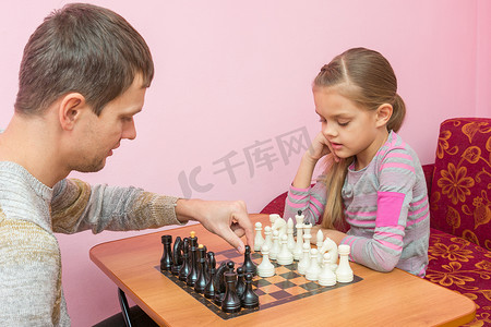 爸爸教他的女儿下国际象棋的第一步