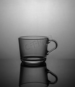 器皿摄影照片_深色背景中带背光的空茶杯