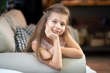 一个躺在沙发上，靠在手臂上的小女孩的画像
