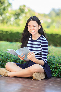 少儿笑脸摄影照片_亚洲女孩和学校书本在手露齿笑脸与快乐