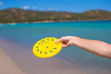 飞盘协会招新摄影照片_绿松石海背景下的黄色飞盘特写
