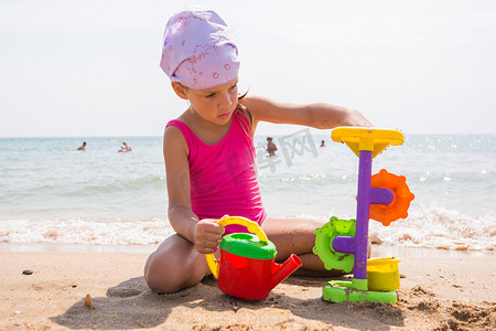 一个孩子在沙滩上的沙子里玩玩具
