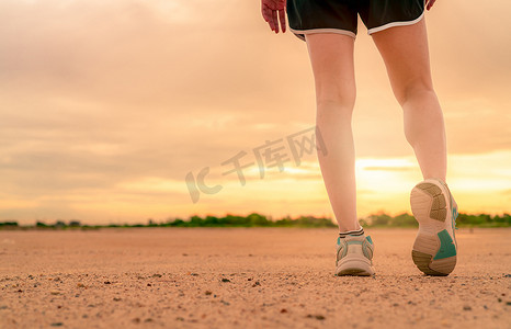 新年跑步摄影照片_女跑步者穿运动鞋，在跑前热身