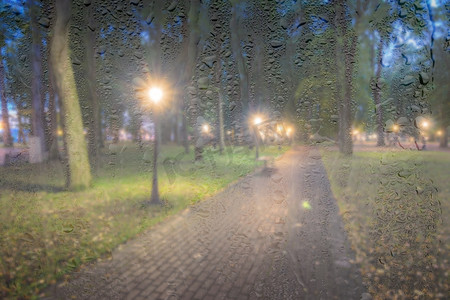 在 ni 的雨天、湿玻璃后面放着灯笼的散焦夜间公园