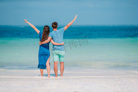 海边情侣摄影照片_在海滩上戴着太阳镜的幸福情侣的照片