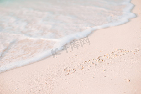 沙滩上手写的 Word 夏季，背景是柔软的海浪