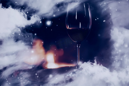 冬季气氛和圣诞假期，壁炉前的一杯葡萄酒，窗玻璃上覆盖着雪花，假期背景