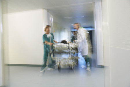 医务人员用轮床运送病人穿过医院走廊