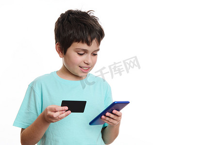 移动电子支付摄影照片_聪明的少年将数据从信用卡传输到智能手机上的移动应用程序，进行在线支付，隔离在白色