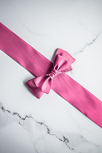生日会背景摄影照片_大理石背景上的粉色丝带和蝴蝶结，女婴送礼会