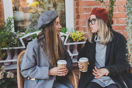 肖像年轻女性最好的朋友在空闲时间互相交谈讨论有趣的主题嬉皮士女孩开玩笑和一起玩乐享受休闲与咖啡继续城市背景