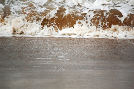 沙子上的波浪飞溅专注于沙子