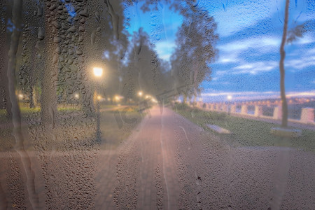 在 ni 的雨天、湿玻璃后面放着灯笼的散焦夜间公园