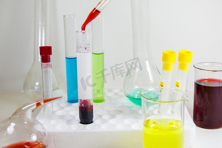 器皿摄影照片_无菌台、玻璃器皿和吸管中的实验室化学液体元素和研究诊断、仪器和物品。