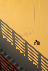 粉色台阶摄影照片_在原来的黄色墙壁上的灰色台阶