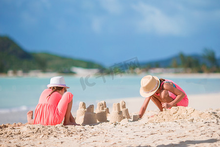 沙滩上的孩子摄影照片_可爱的小孩在白色的沙滩上玩沙子