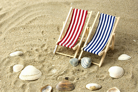 沙滩椅摄影照片_沙滩上的两张沙滩椅被贝壳包围