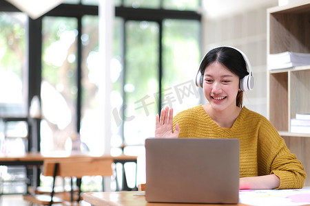 zoom摄影照片_亚洲女学生在线学习班学习在线视频通话 zoom 老师，快乐的亚洲女孩用电脑笔记本电脑在线学习英语。