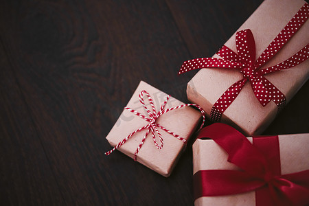 传统经典摄影照片_礼品和传统节日礼物，木制背景的经典礼盒，用红丝带工艺纸包裹的礼物，季节性假期的复古乡村风格