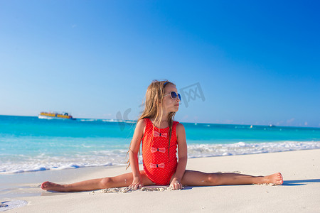沙滩上的孩子摄影照片_小女孩坐在白色沙滩的裂缝上