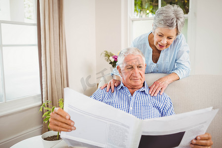 老年妇女与老人阅读报纸交谈