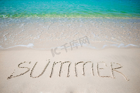 沙滩上手写的 Word 夏季，背景是柔软的海浪