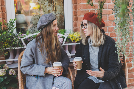 年轻女性最好的朋友在空闲时间互相交谈讨论有趣的主题嬉皮士女孩开玩笑和一起玩乐享受休闲与咖啡继续城市背景