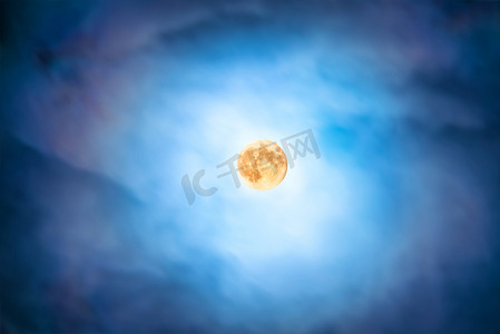 黄色月光摄影照片_透过移动的蓝云在满月的夜景
