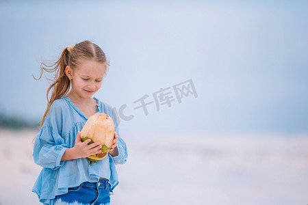 白色沙滩上有大椰子的小可爱女孩