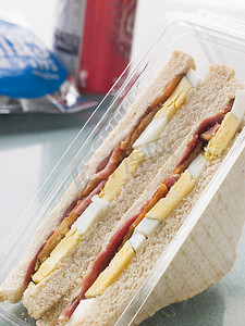 薯片袋摄影照片_白面包上的鸡蛋和培根三明治，配一袋薯片和一个