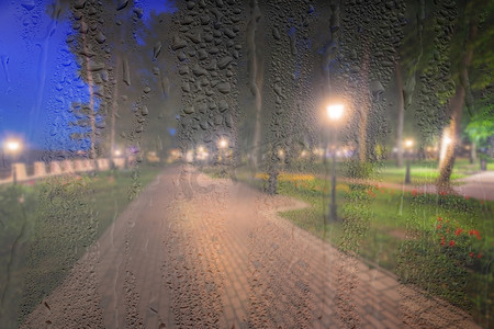 在 ni 的雨天、湿玻璃后面放着灯笼的散焦夜间公园