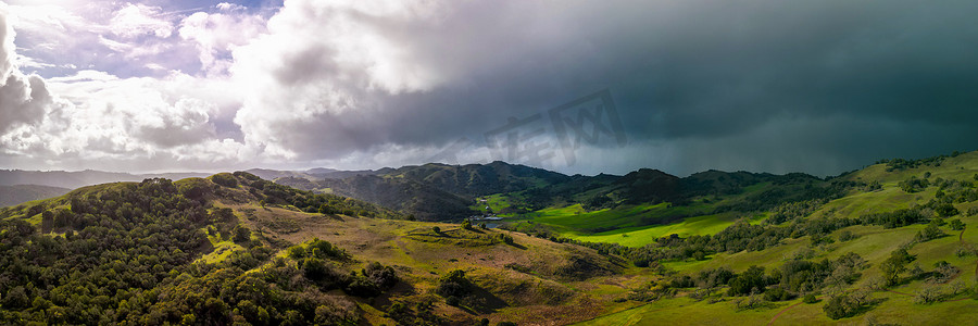 降雨图摄影照片_明亮的太阳和黑暗的暴风云全景在绿色加利福尼亚风景