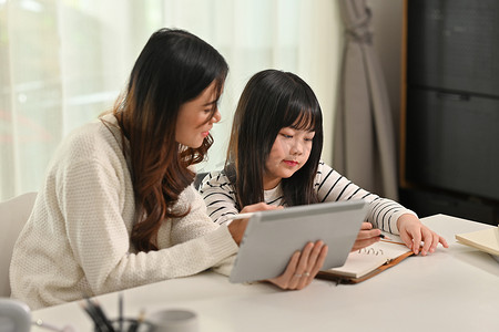 有兴趣的亚洲女孩在家和家教一起工作。