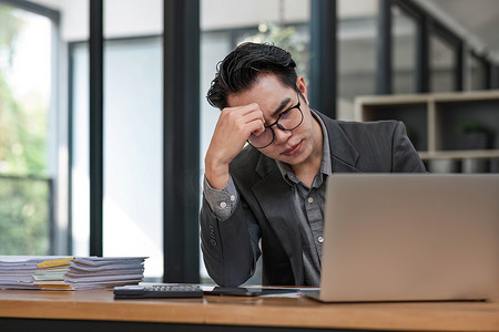 悲伤抑郁严重的人从工作中学习压力概念。亚洲人在使用计算机工作场所感到疲倦痛苦。概念全球经济，健康问题