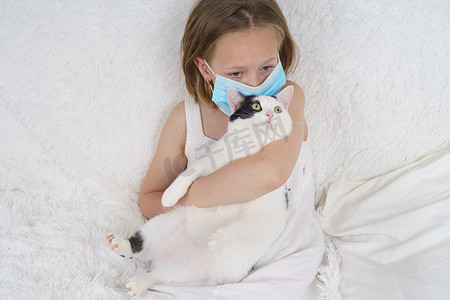 戴着防护面具的生病少女抱着一只猫。