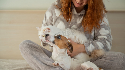 红发白种女人抱着一只狗和一只猫。