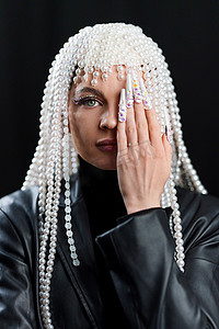 戴珍珠假发的女人用手遮住一只眼睛